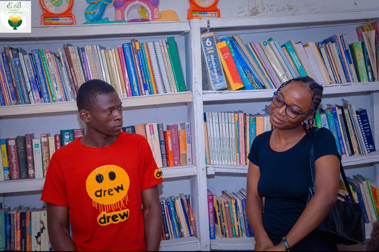 Visitors standing beside the library bookshelves